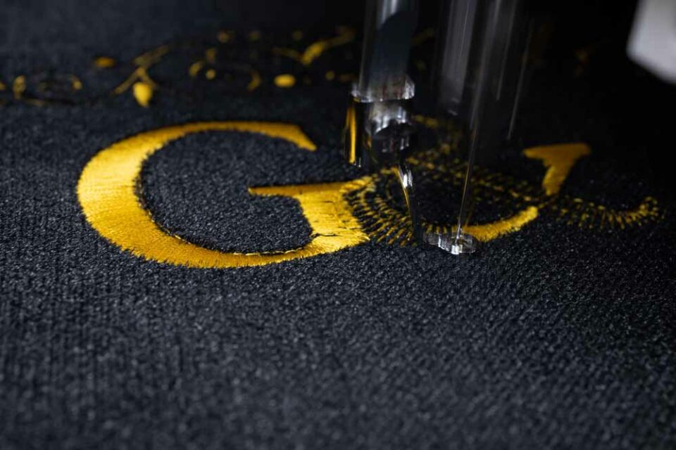 Machine embroidery on black velvet fabric with yellow thread. Em