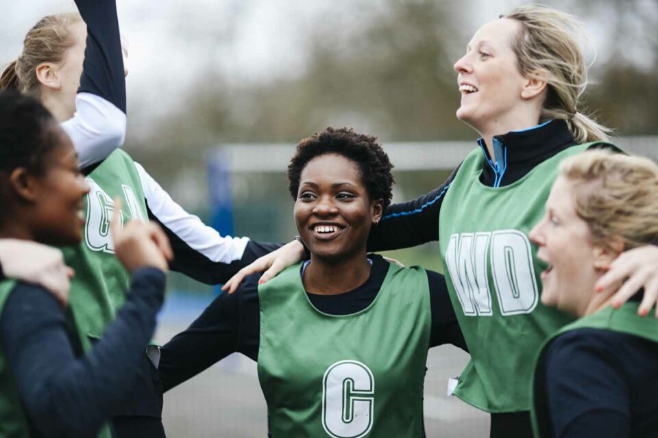 Female netball team celebrating win on netball court